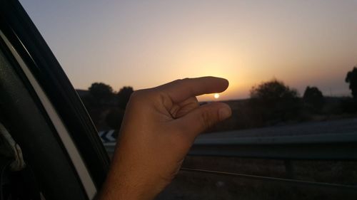 Midsection of man against sky during sunset