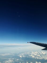 Aerial view of airplane wing against blue sky