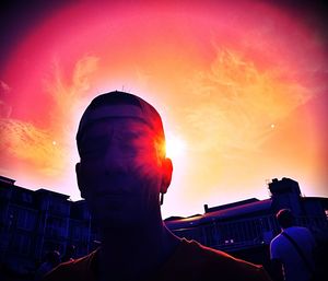 Rear view of silhouette man against orange sky