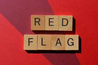 Red flag, words in wooden alphabet letters isolated on red background as banner headline