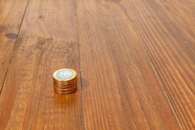 High angle view of coins on wooden table