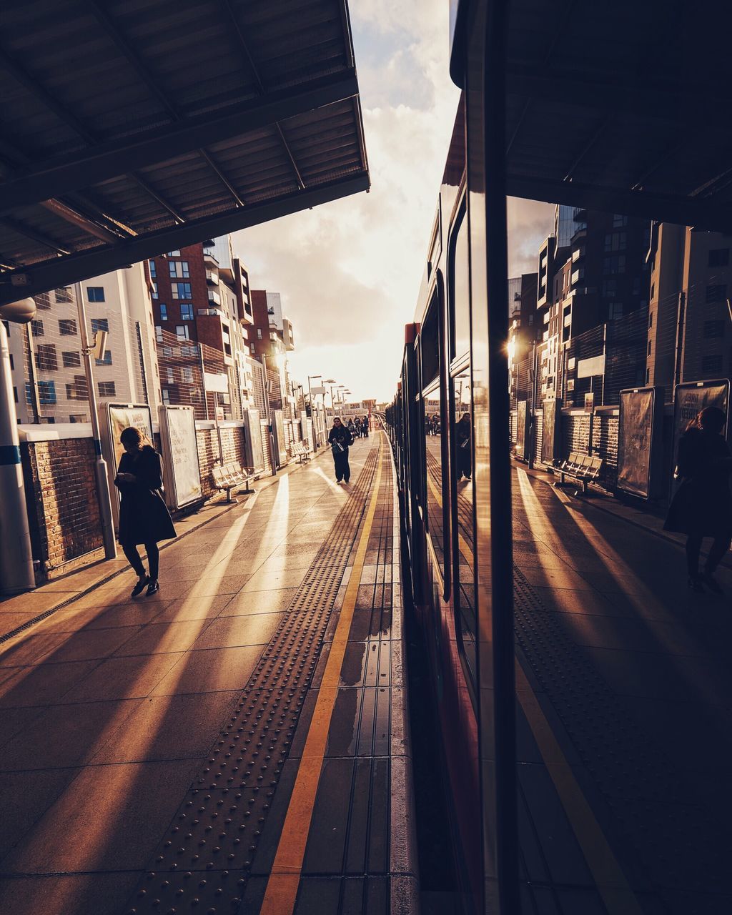 transportation, the way forward, built structure, architecture, building exterior, city, diminishing perspective, sky, railroad track, vanishing point, men, city life, walking, street, mode of transport, incidental people, railroad station platform, road