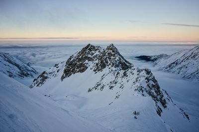 Scenic view of snow covered mountains against sky during sunset