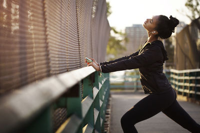 Jogger listening to music while exercising on footpath