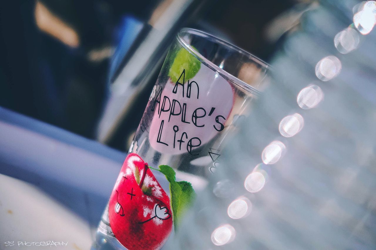 CLOSE-UP OF GLASS WITH TEXT ON BACKGROUND