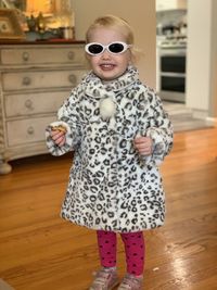 Portrait of girl wearing sunglasses standing on wooden floor