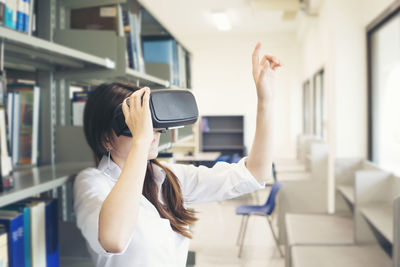 Female student using virtual reality simulator in library