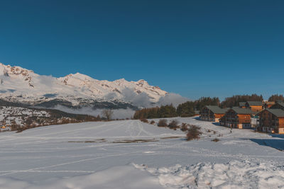 A picturesque landscape view of the snowcapped french alps mountains and the ski resort buildings