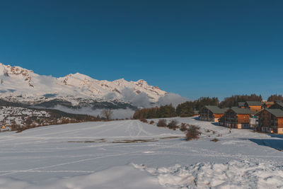 Scenic view of snowcapped mountains against clear blue sky