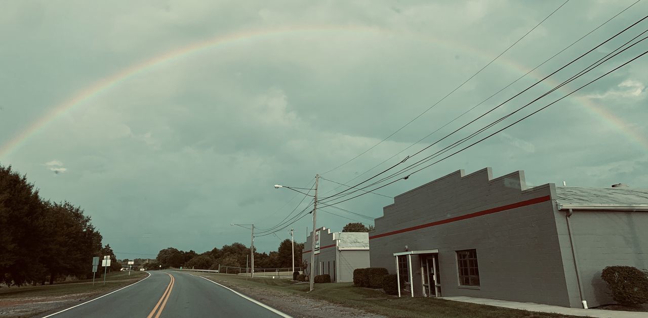 PANORAMIC VIEW OF RAINBOW OVER CITY STREET