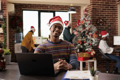 Portrait of young man using laptop while sitting on table