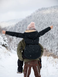 Rear view of person standing on snow covered land