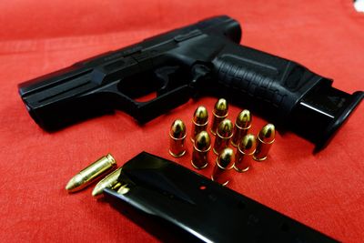 Close-up of gold bullets and handgun on table