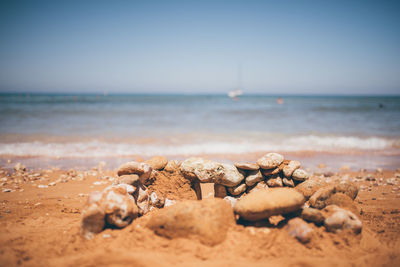 Surface level of sand on beach against clear sky