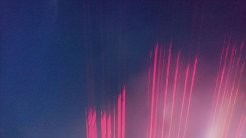 Low angle view of illuminated lights against sky at night