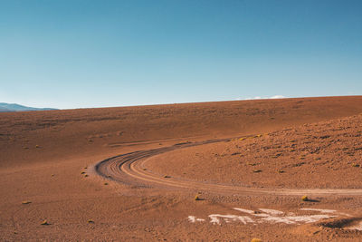 Scenic view of desert against clear blue sky