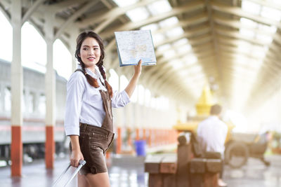 Portrait of young woman standing in city