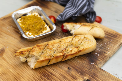 Chopping board with baguette and grilled cheese