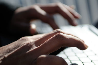 Close-up of hands using laptop