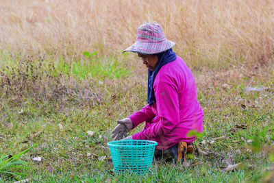 Side view of woman picking corn