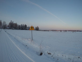 Scenic view of snow covered field against sky