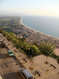 High angle view of cityscape by sea against clear sky