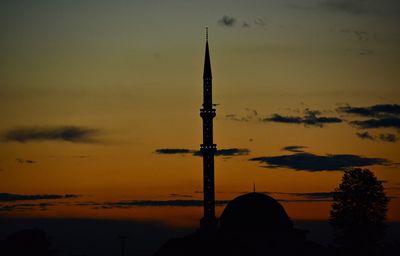 Silhouette tower by building against sky during sunset