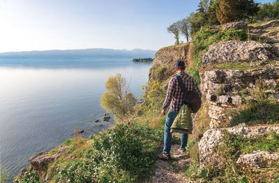 Man standing walking on pathway by sea