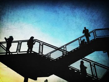 Low angle view of silhouette people against sky