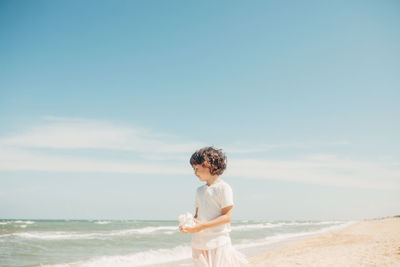 Full length of man standing on beach against sky