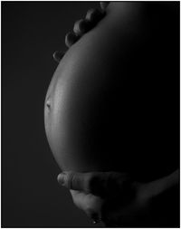 Close-up of human hand against clear sky over black background