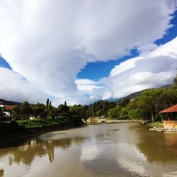 Scenic view of lake and mountains against cloudy sky