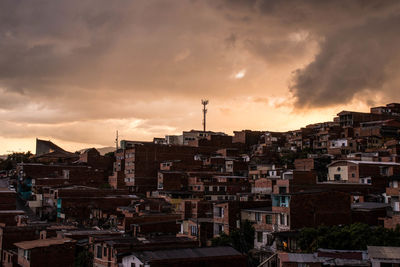 Buildings in city against dramatic sky