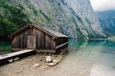 Built structure by lake against mountain