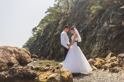 Rear view of couple walking on rock