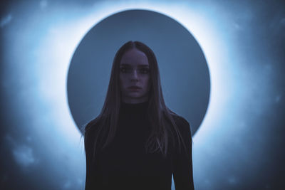 Young woman standing against wall