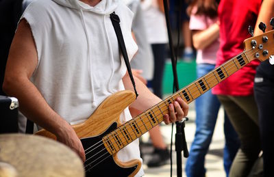 Midsection of man playing guitar