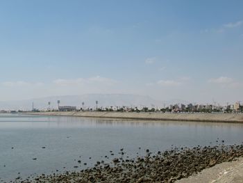 Scenic view of sea by buildings against sky