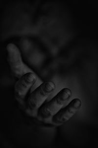 Close-up of human hand against black background