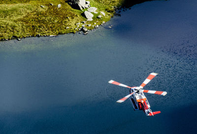 Helicopter flying over river against sky