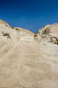 Scenic view of desert against clear blue sky