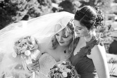 Bride with friend holding bouquets