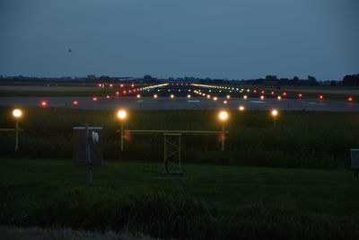 Illuminated field against sky at night