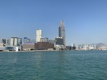 Modern buildings in city against clear blue sky