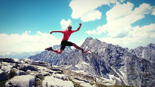 Low angle view of woman jumping on rock