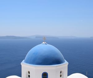 Close-up of cross against clear blue sky