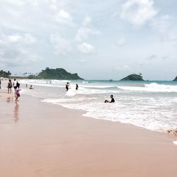 People on beach against sky