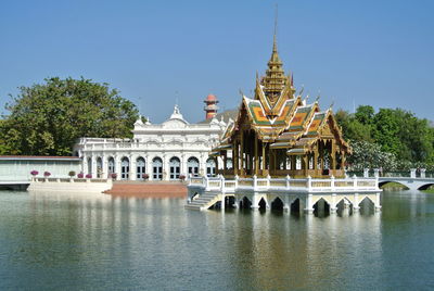 Temple by building against clear sky