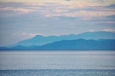 Scenic view of sea and mountains against sky