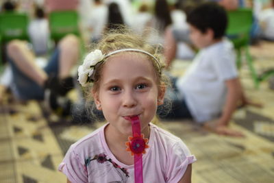 Portrait of smiling girl holding wrist watch in mouth